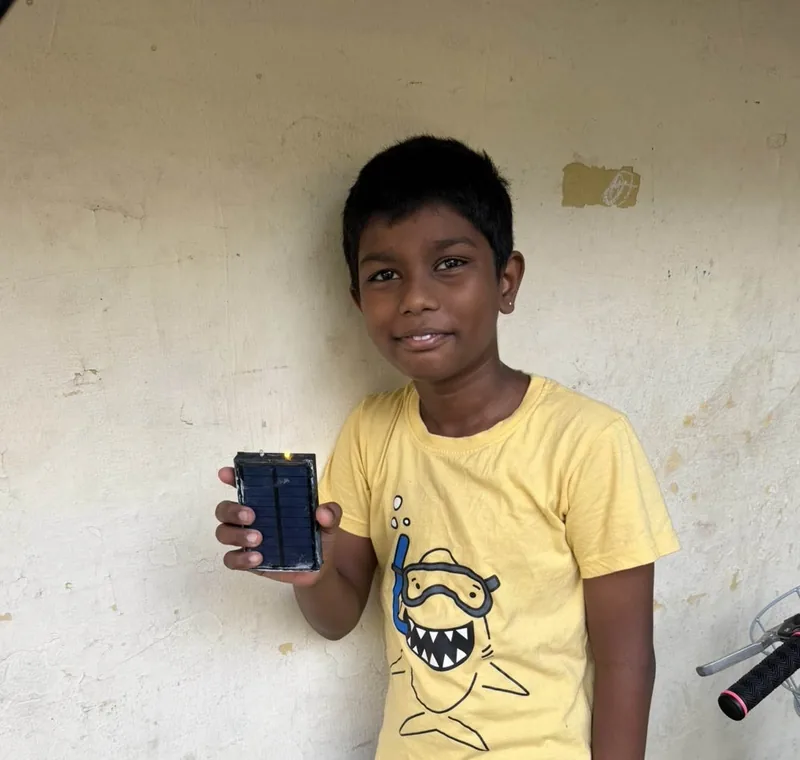 A child smiling with the solar flashlight they received